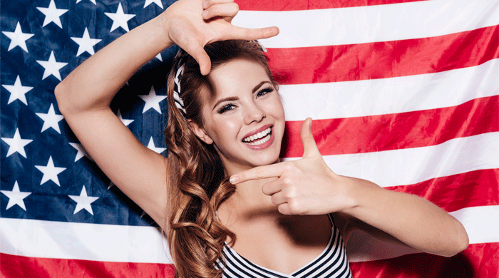 woman smiling in front of an american flag