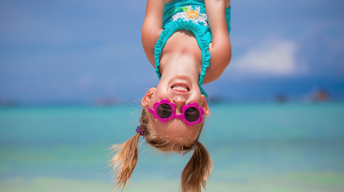 Little girl in bathing suit hanging upside down