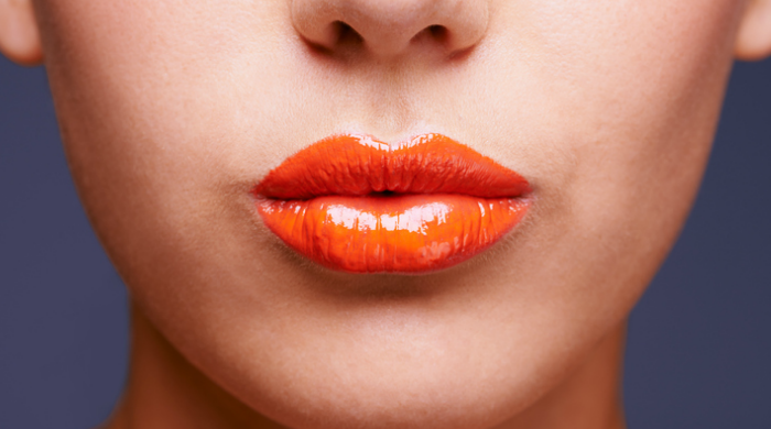 Woman wearing orange lip gloss