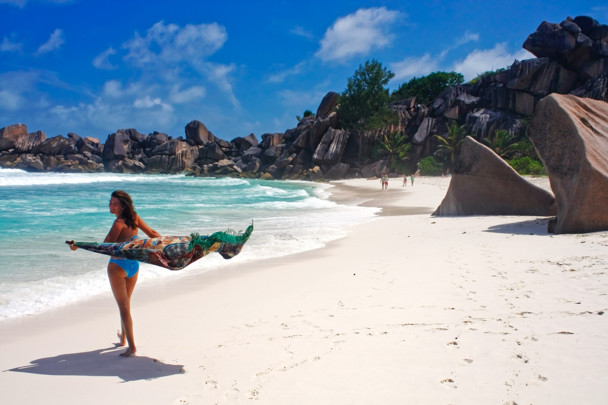 Young woman walking on tropical beach called Grande Anse, La Digue Island, Seychelles, Indian Ocean.