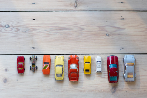 Toy cars lined up in a row on floor