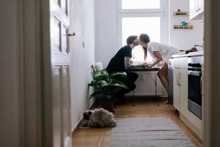 Young couple sitting in kitchen having a romantic moment