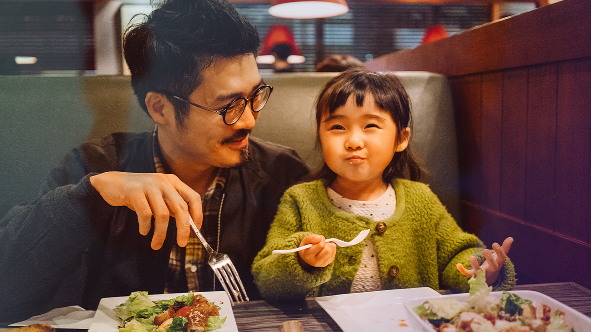 Dad and child eating at a restaurant
