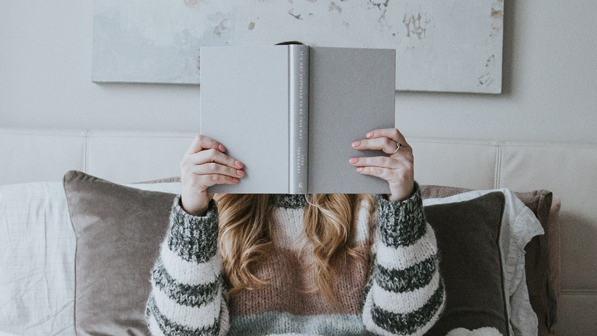 Girl holding book in front of her face