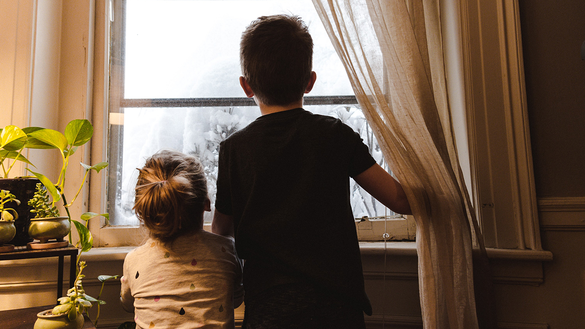 Two kids looking out the window