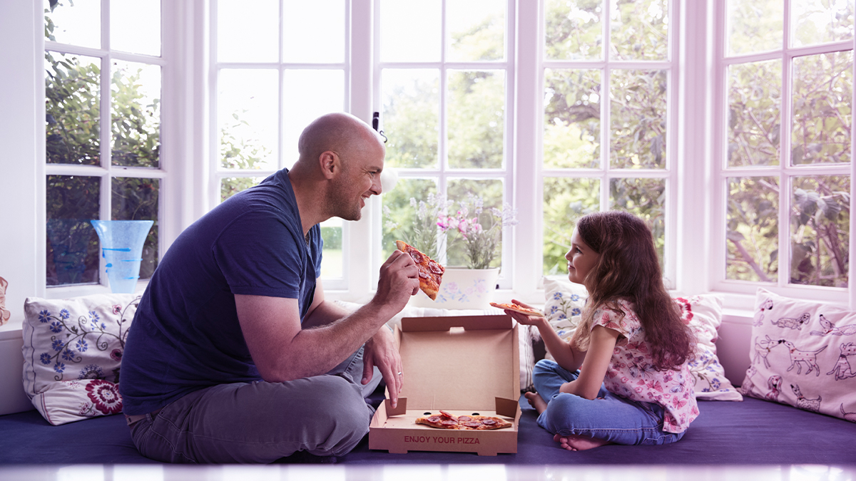 Dad and daughter eating pizza